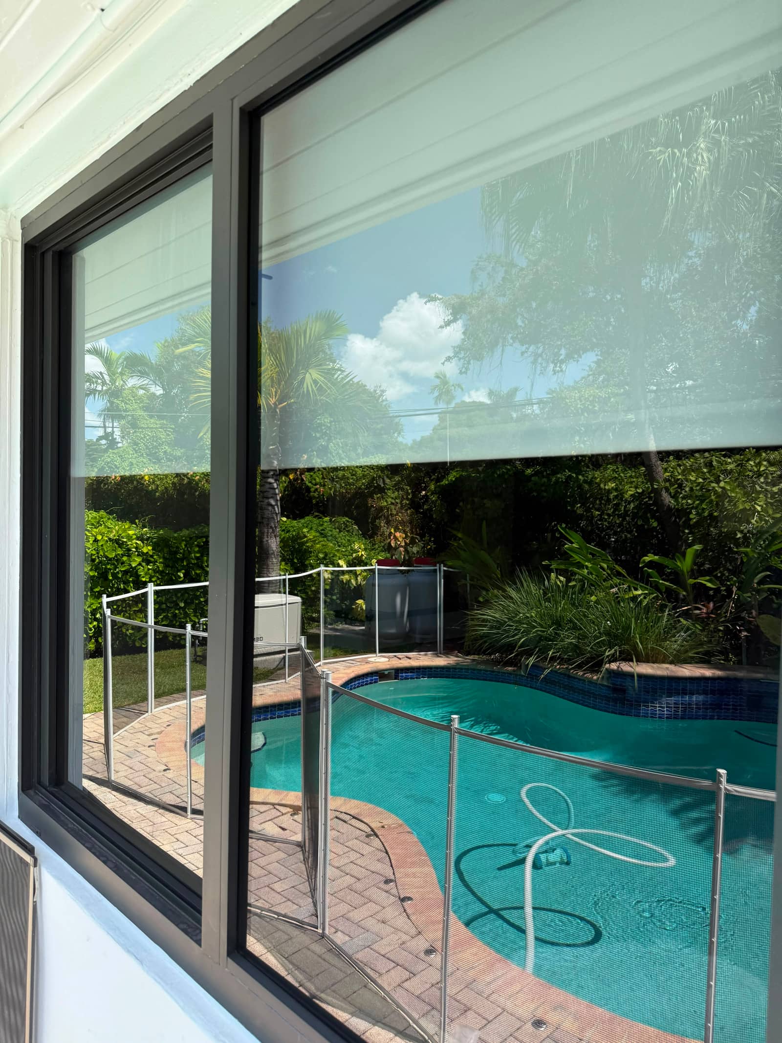 Crystal-clear sliding glass door freshly cleaned by Crystal Cleaning 305, with a bright view of a Miami backyard pool and palm trees